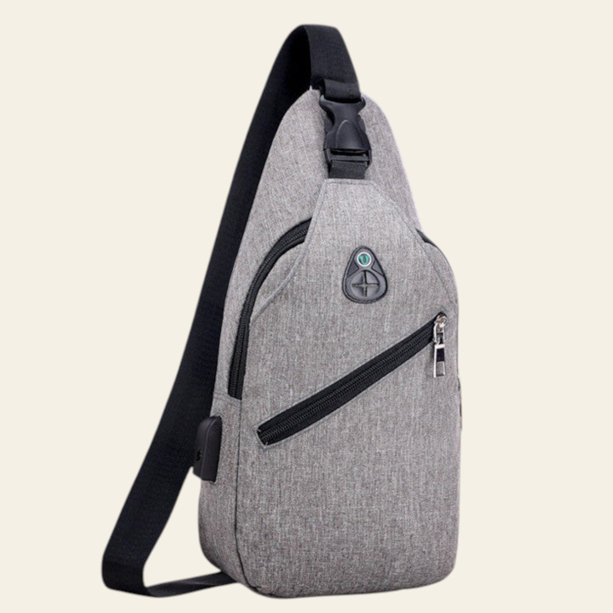 Gray sling bag with black straps against a blurred natural background