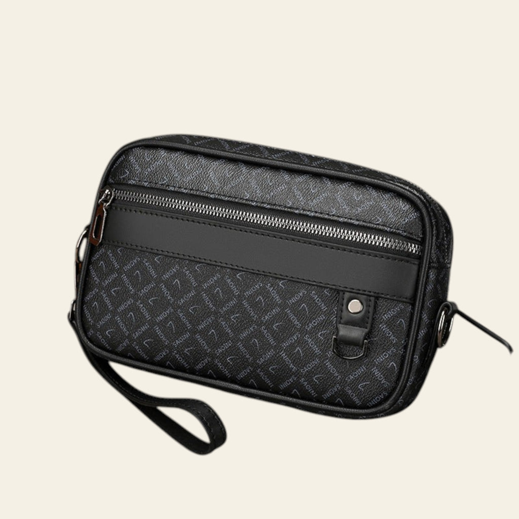 Black patterned bag with a strap on a light gray background