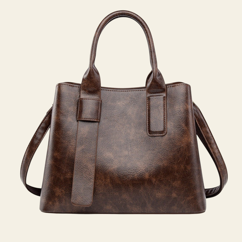 Brown leather handbag with a shoulder strap on a white background