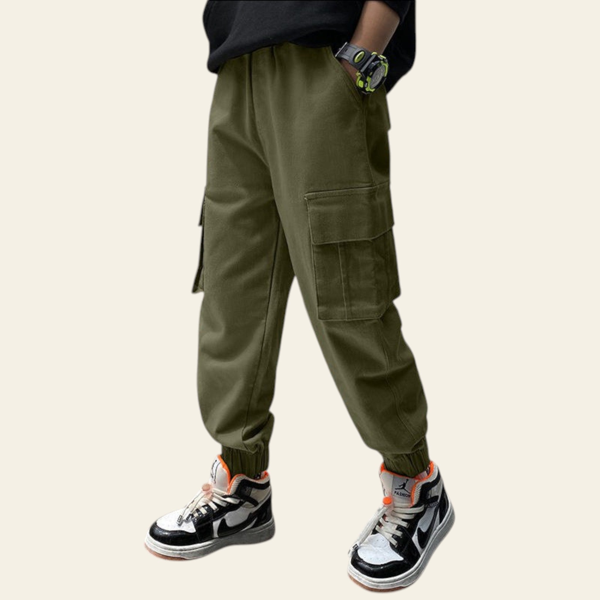 Person wearing green cargo pants and black sneakers in a modern kitchen setting