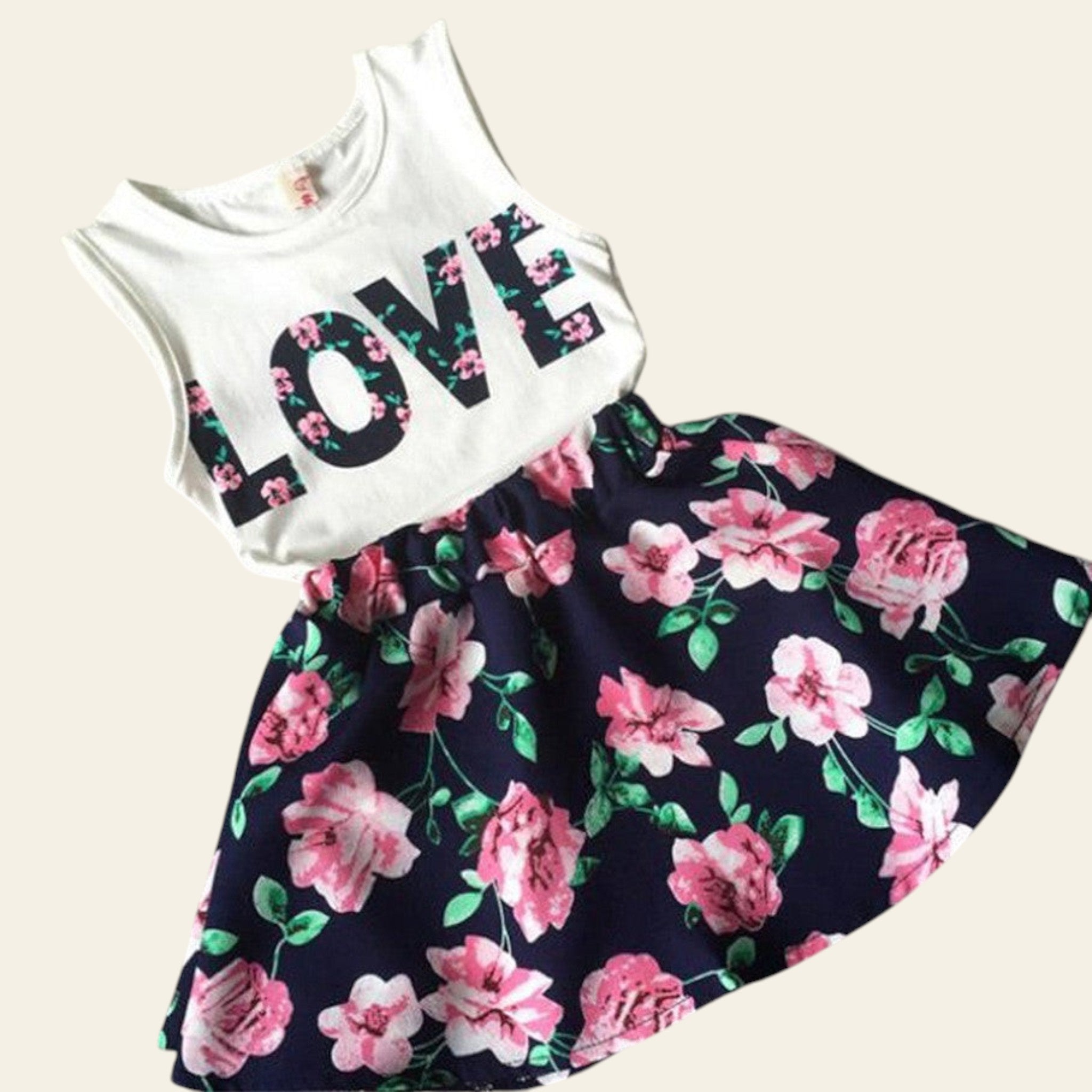 White sleeveless top with 'LOVE' print and floral skirt on a textured surface.