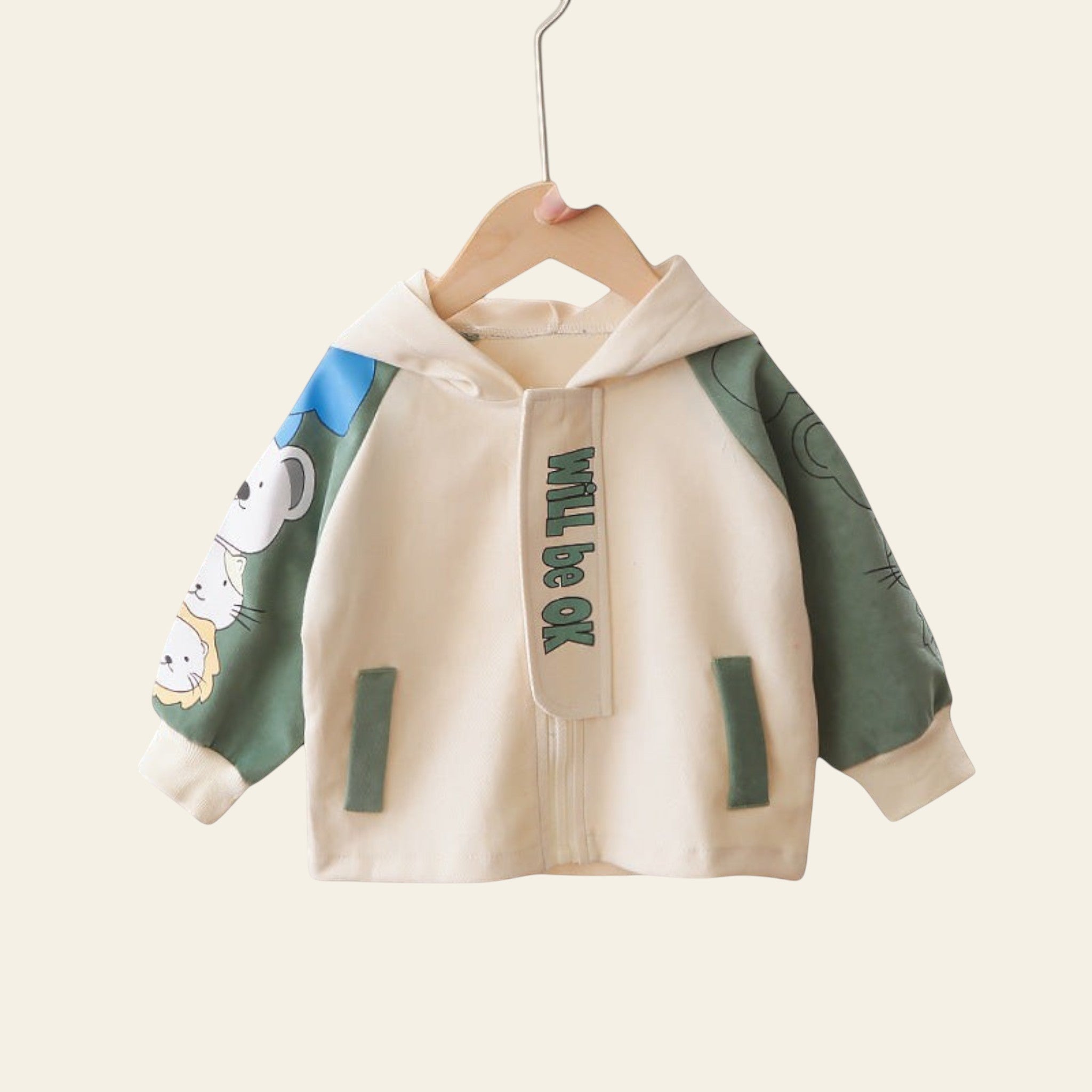 Children's hoodie with cartoon design and text 'Will be OK' hanging on a rack.