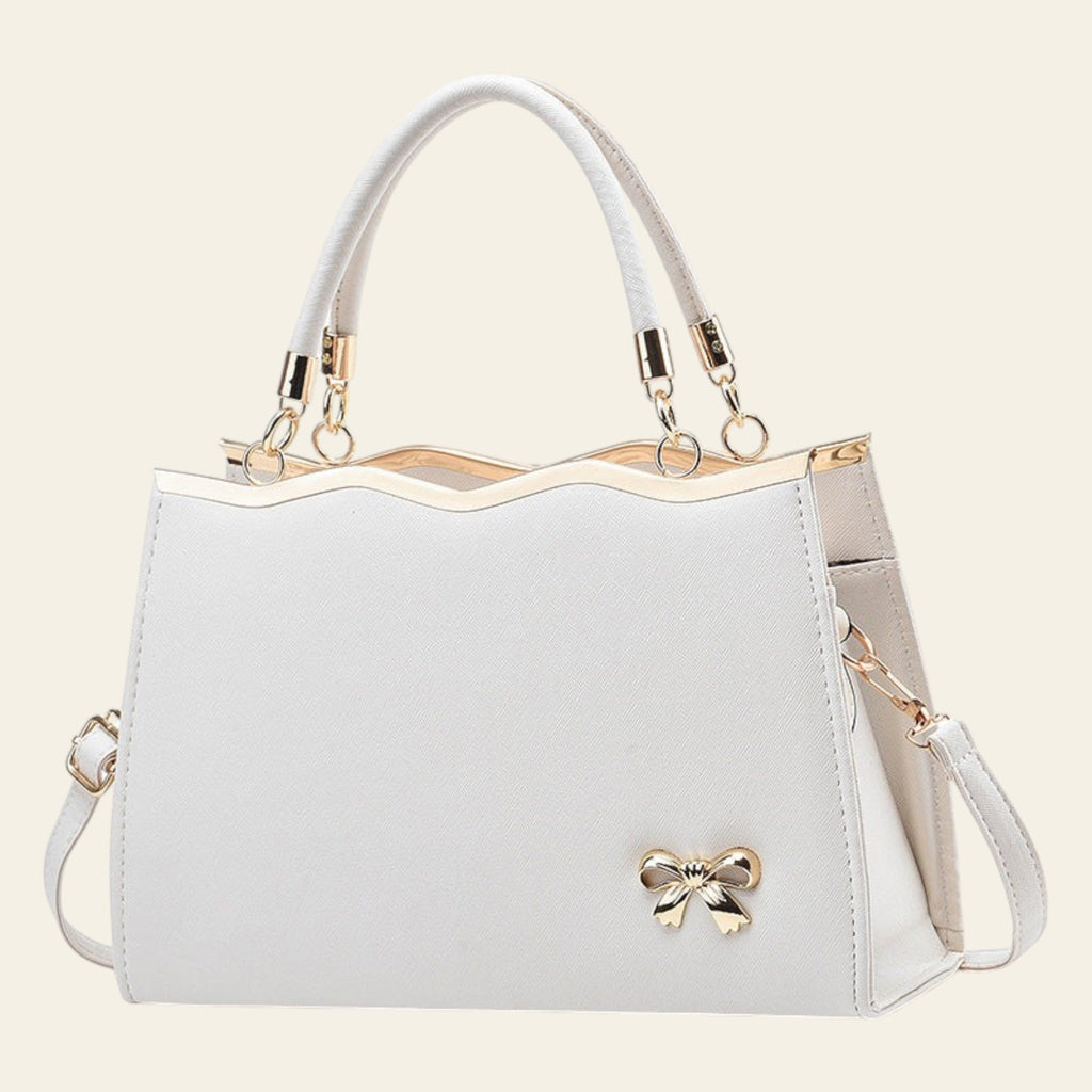 White handbag with gold accents on a white background