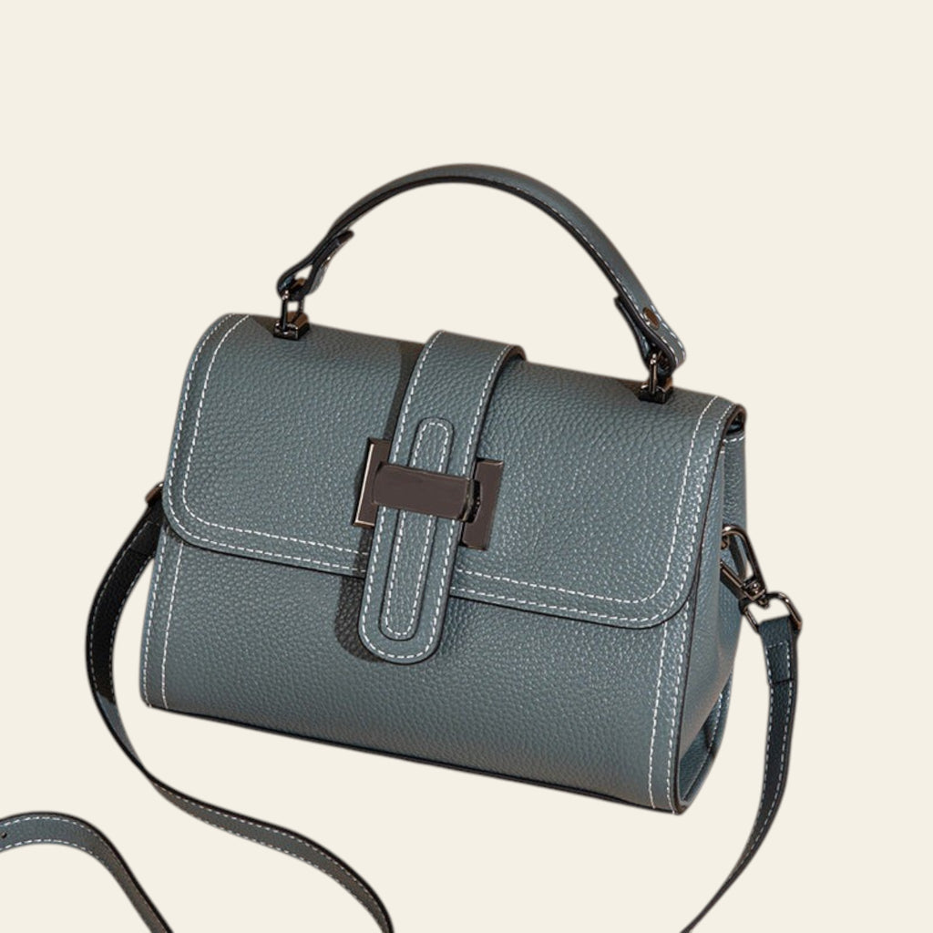 Green handbag with a strap on a beige background