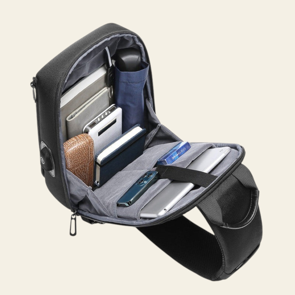 Black backpack with compartments containing electronic devices on a white background