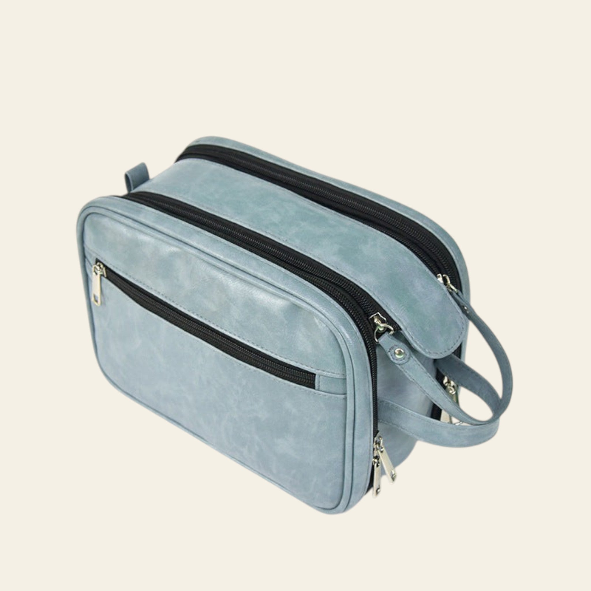 Light blue handbag with black zippers on a white background