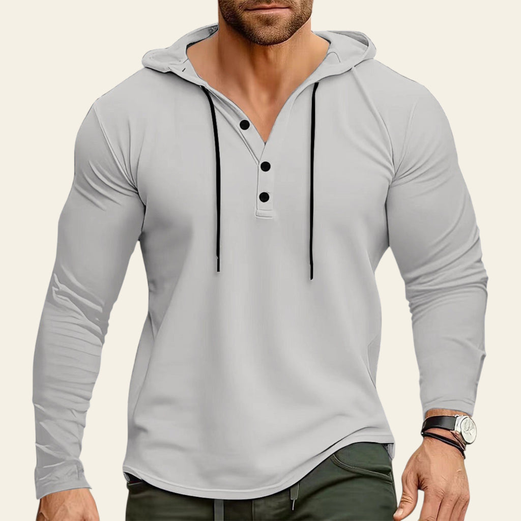 Man wearing a gray long-sleeve hoodie with black buttons against a blurred background