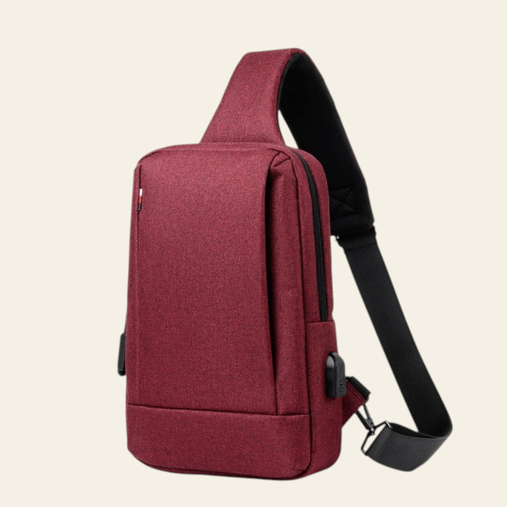Red sling bag with a black strap on a white background