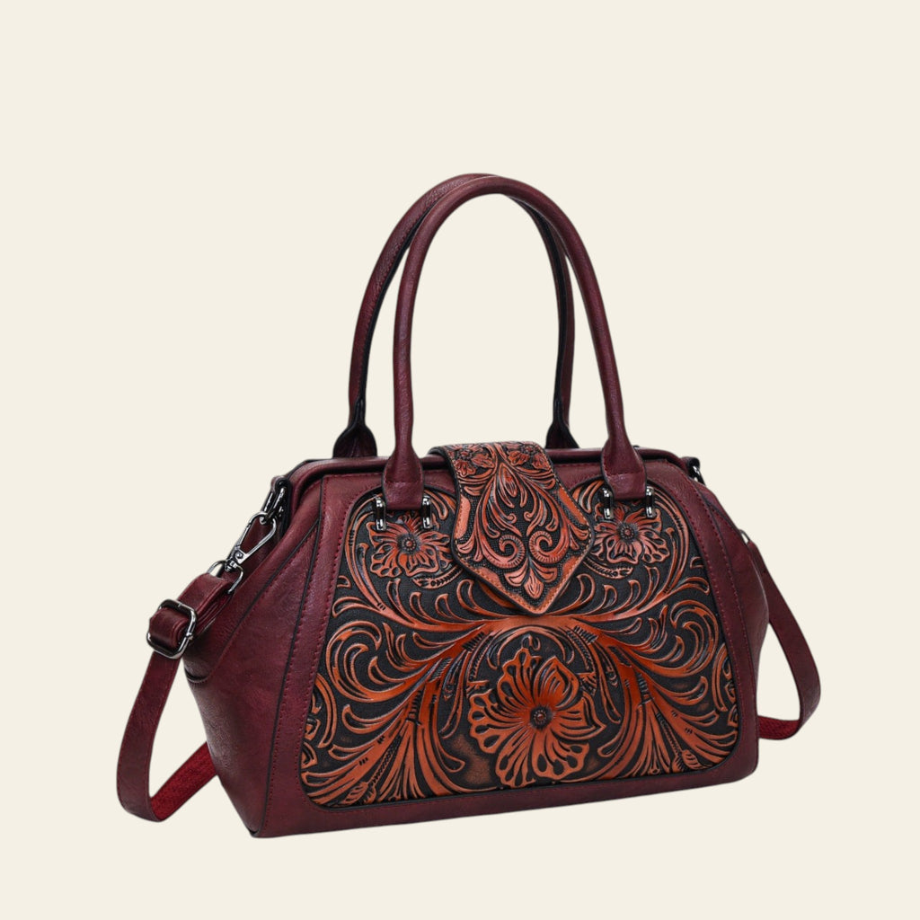 Brown leather handbag with intricate floral patterns on a white background