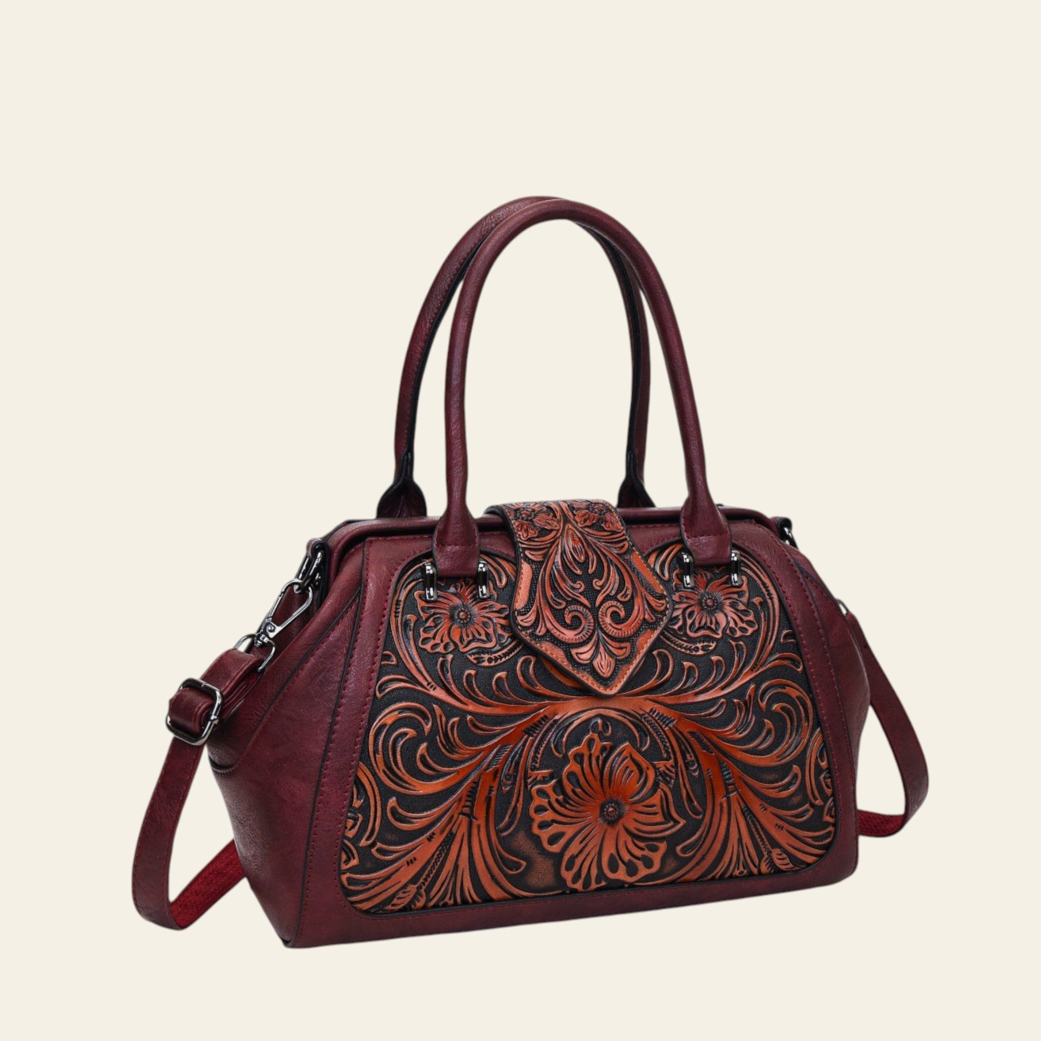 Brown leather handbag with intricate floral patterns on a white background