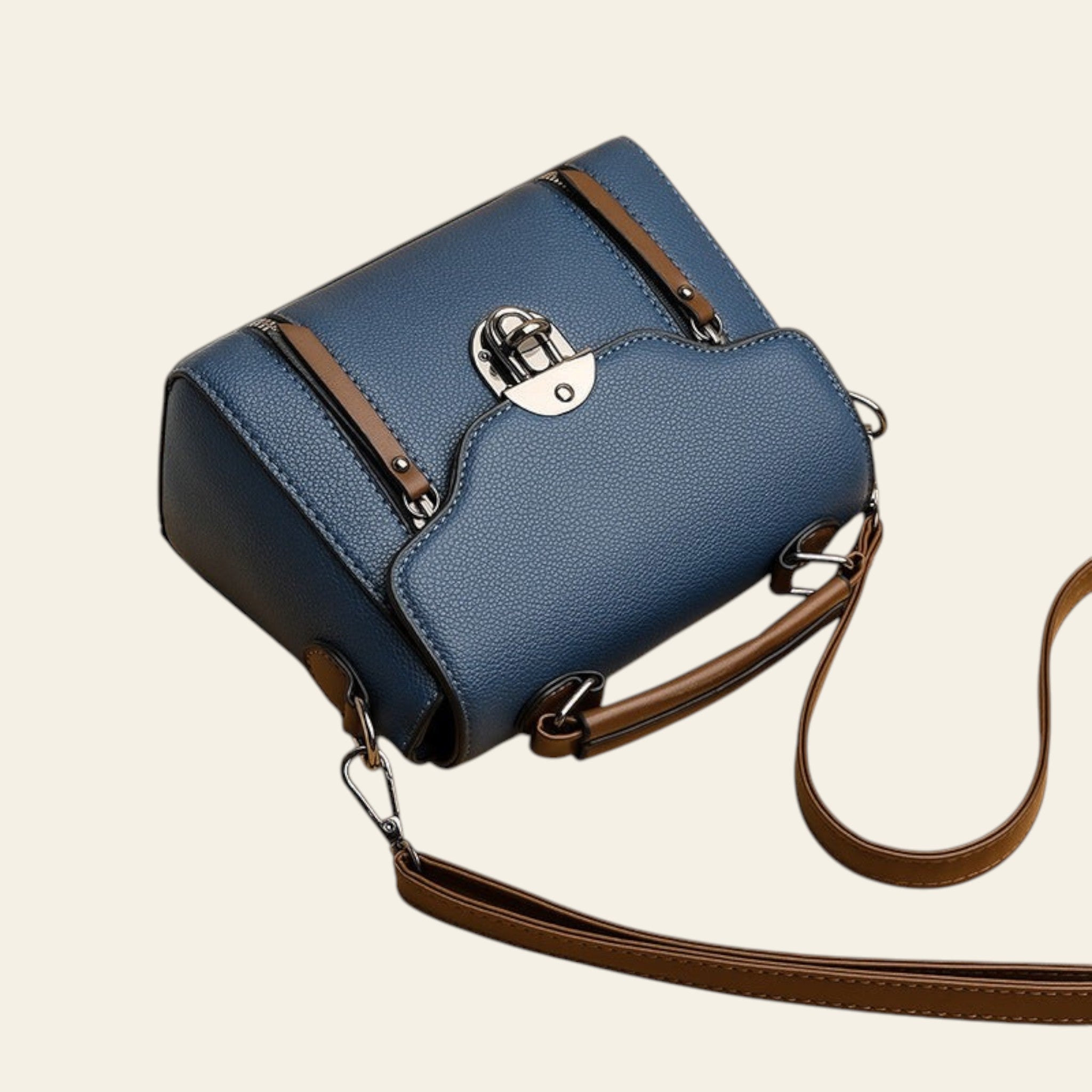 Blue handbag with brown strap on a beige background