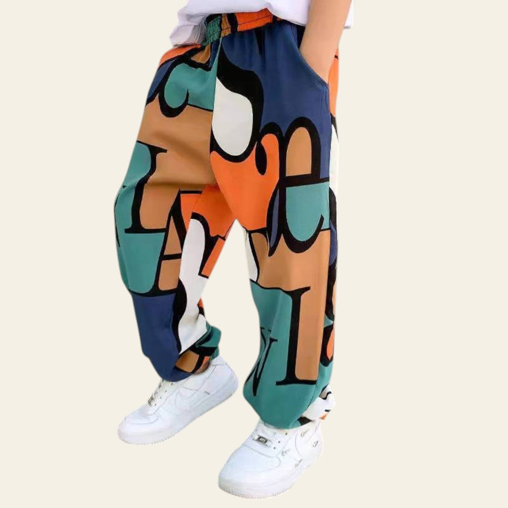 Colorful abstract-patterned pants worn by a person indoors.