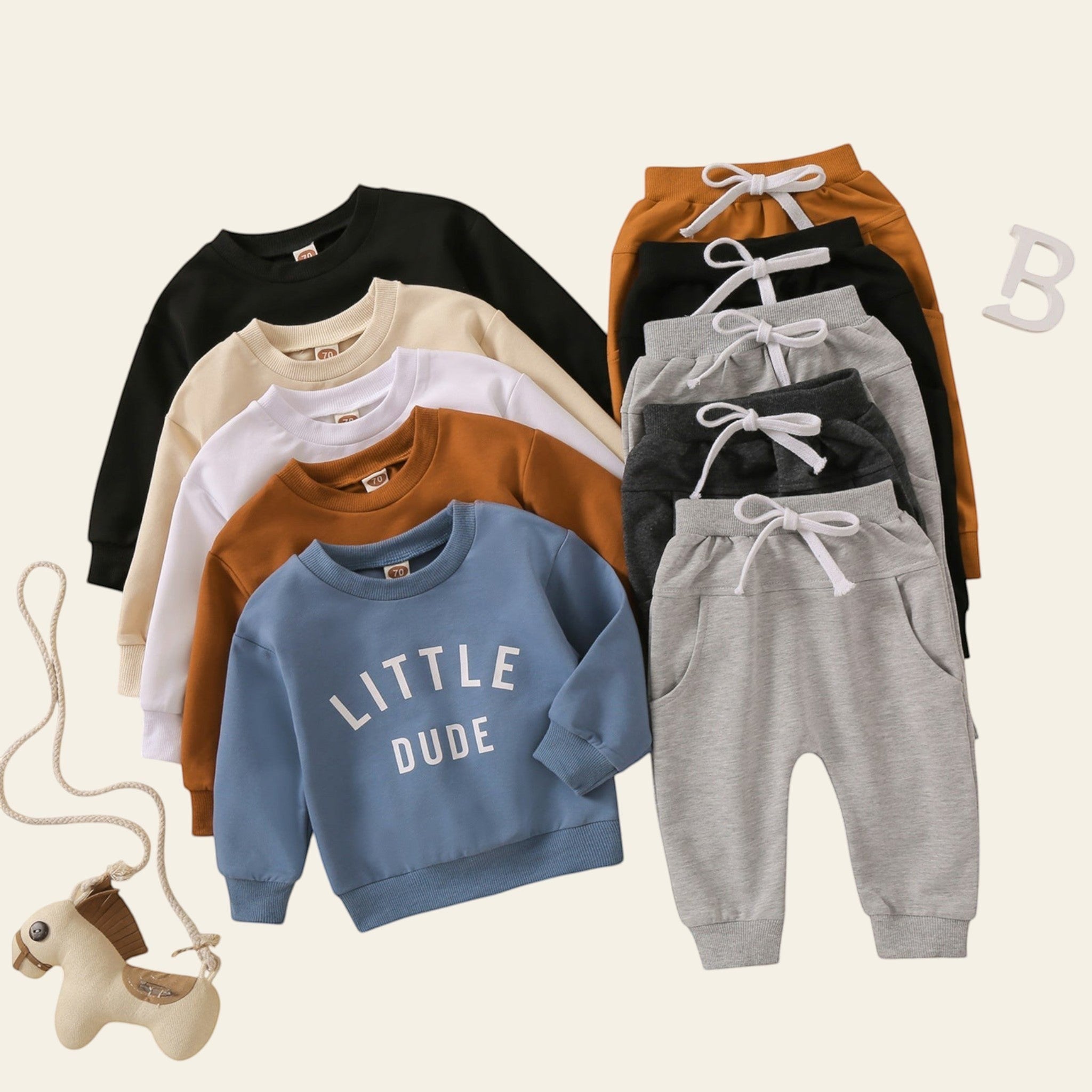 Children's clothing including sweatshirts and pants on a beige background