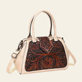 Handbag with floral tooled leather design on a white background