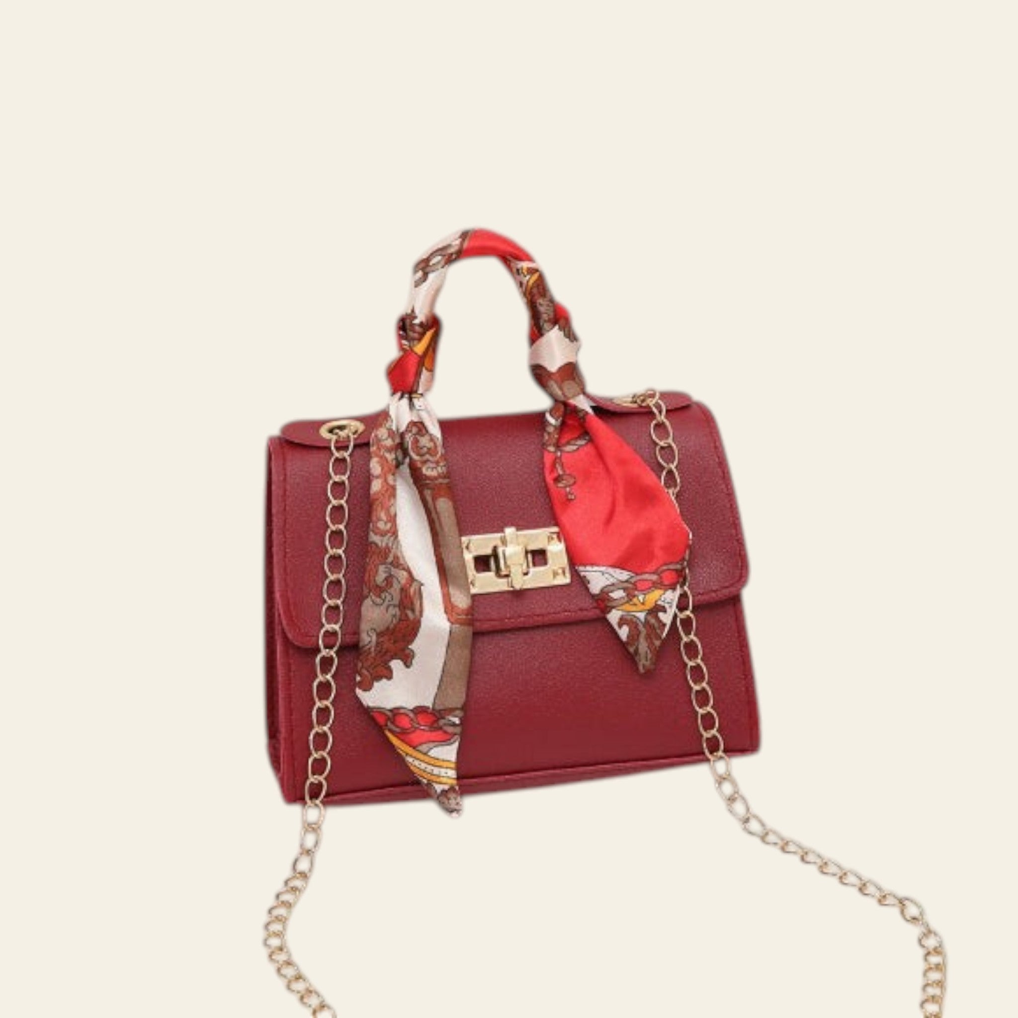 Red handbag with a decorative scarf and gold chain on a light background