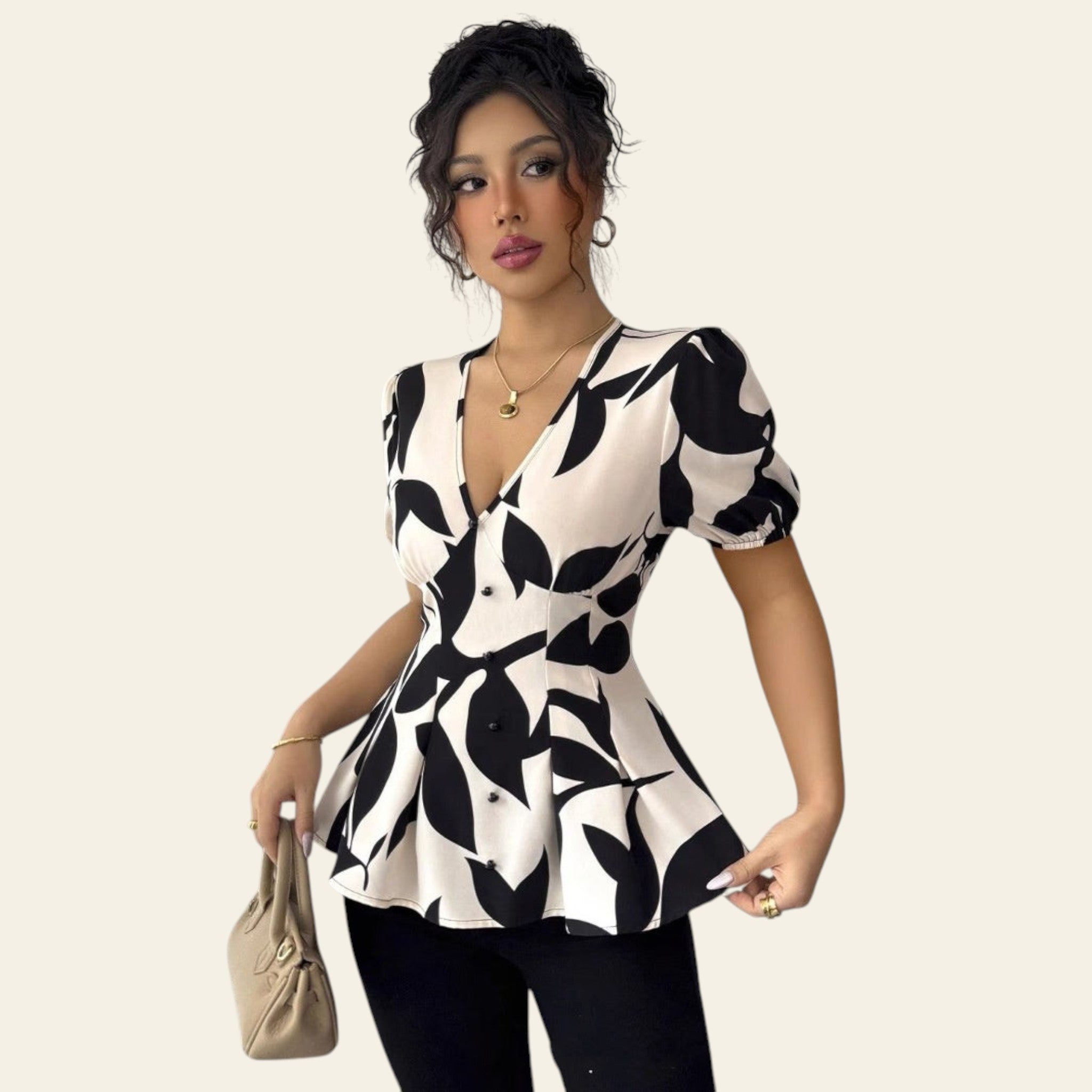 Woman wearing a black and white patterned top against a plain background