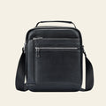 Black leather crossbody bag on a light gray background