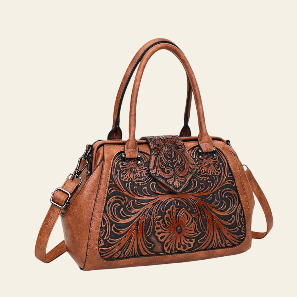 Brown leather handbag with intricate floral patterns on a white background