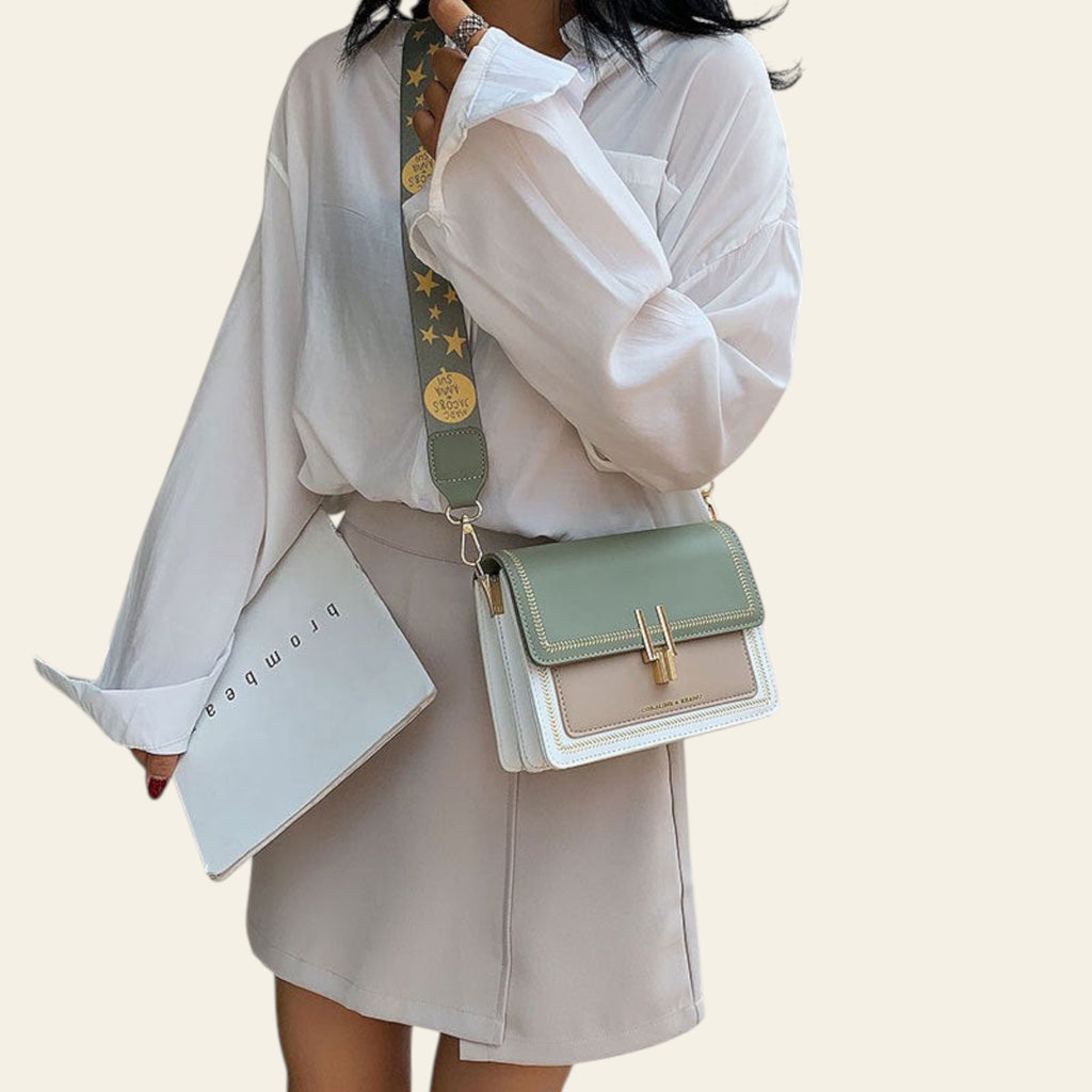 Person wearing a white blouse and beige skirt with a green and beige handbag.