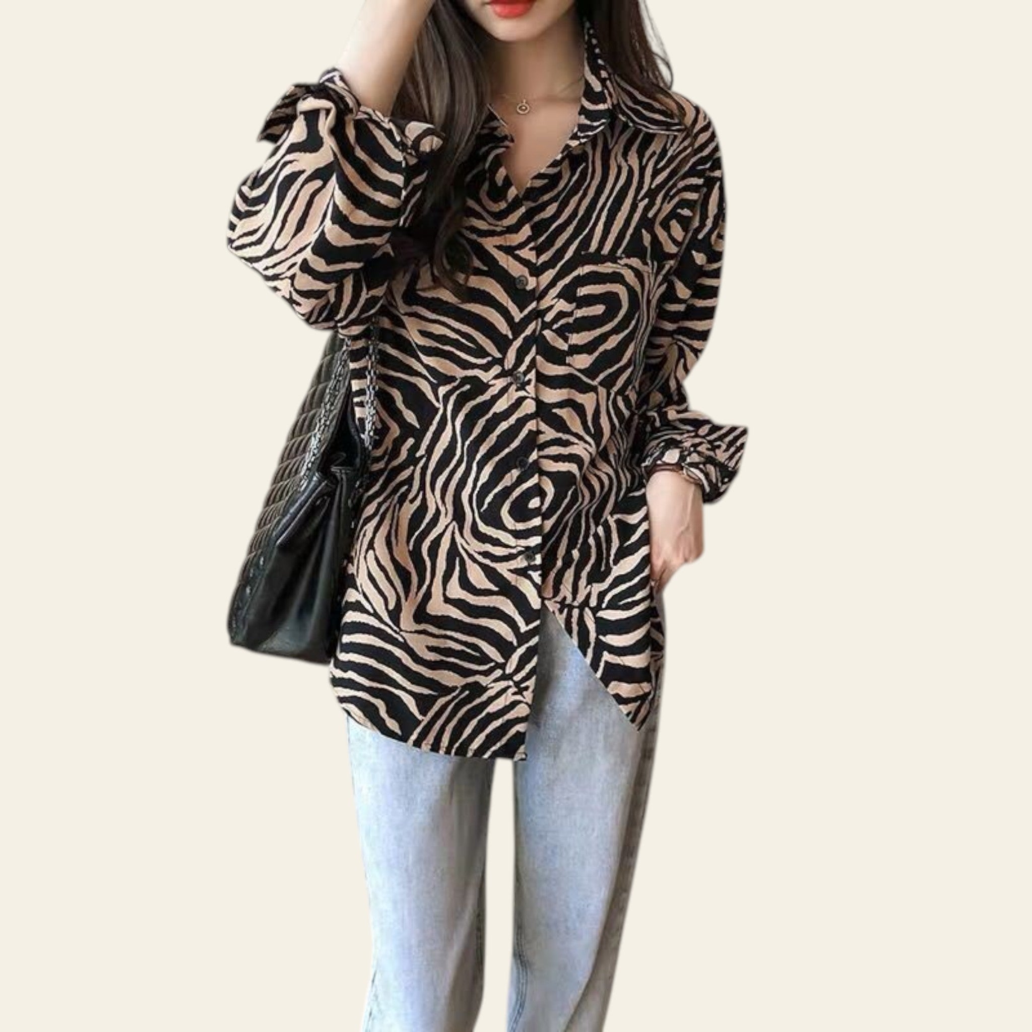 Person wearing a zebra print shirt and light blue jeans against a neutral background