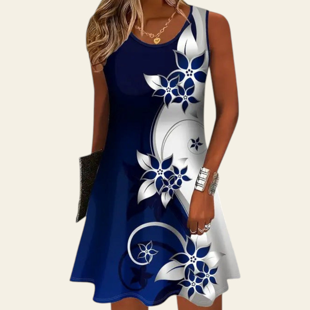 woman wearing a sleeveless blue dress with white floral patterns and a gradient design