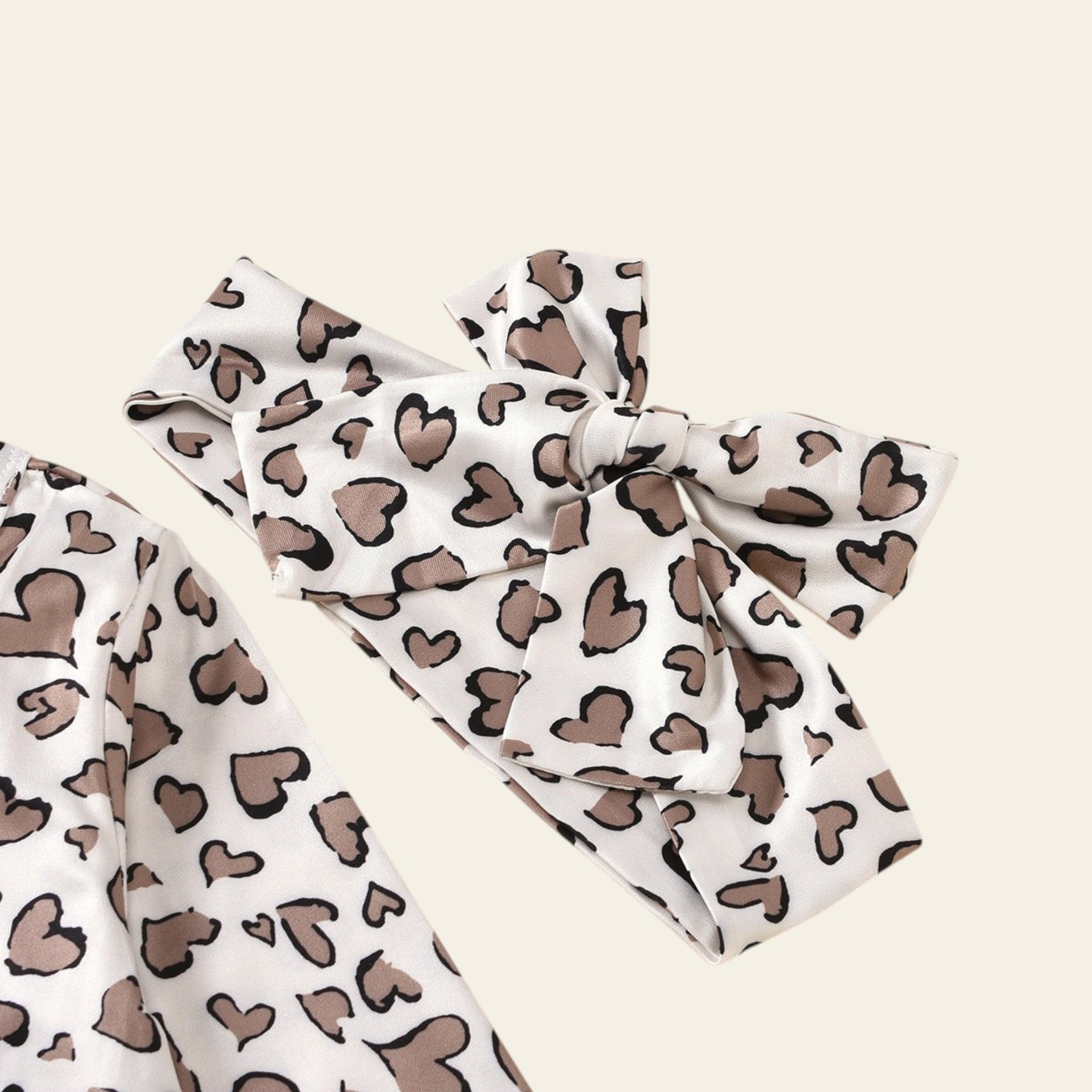White top with brown heart pattern and matching pants on a beige background