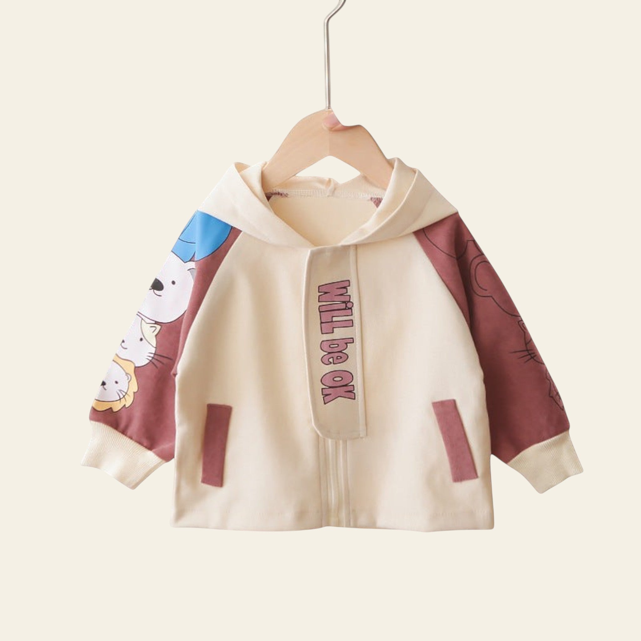 Children's jacket with cartoon design and motivational text on a hanger against a colorful background.