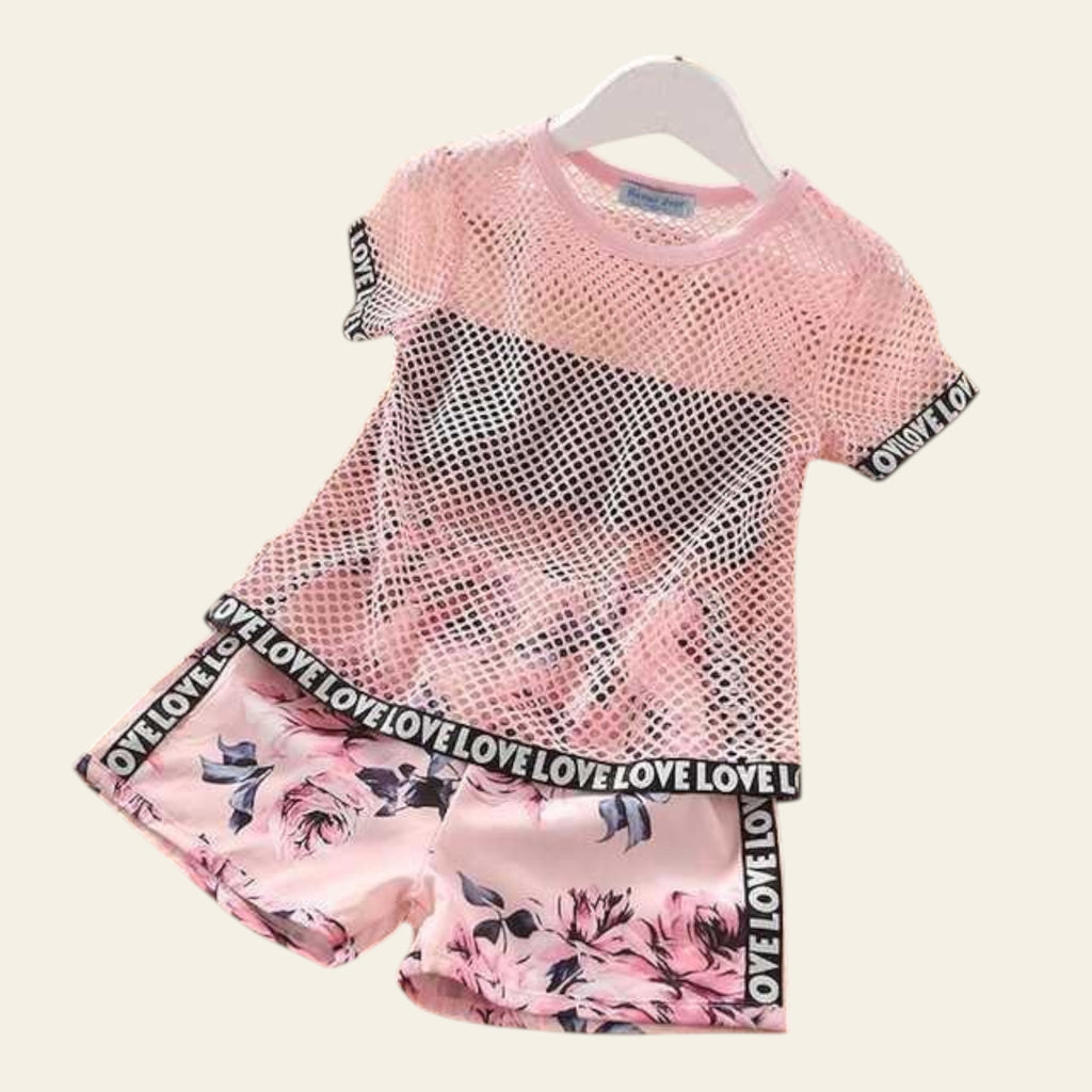 Pink mesh top and floral shorts set on a wooden floor with 'LOVE' printed waistbands.
