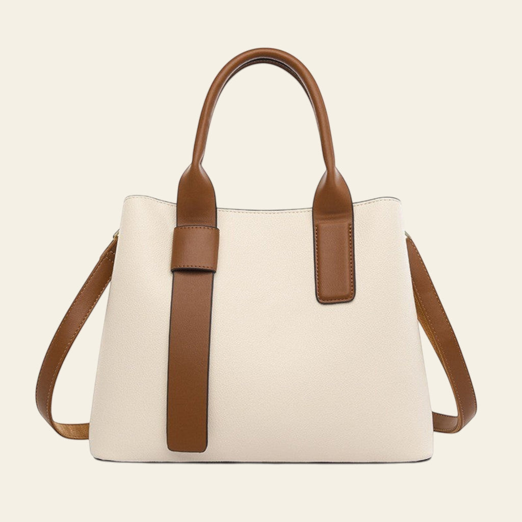 Beige handbag with brown handles and straps on a white background