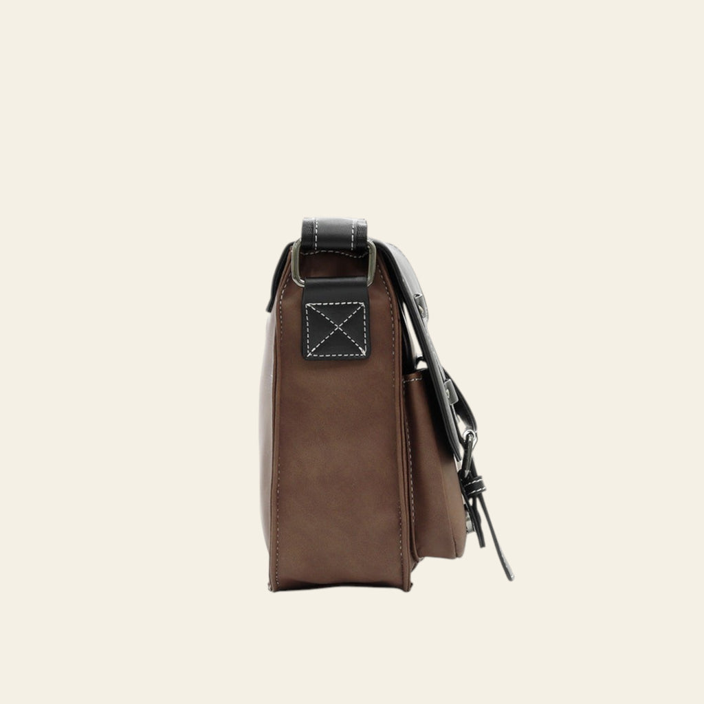 Brown leather bag with a strap on a white background